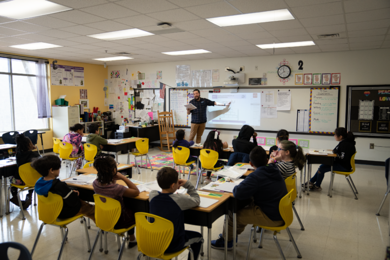 Teacher at whiteboard in front of seated students