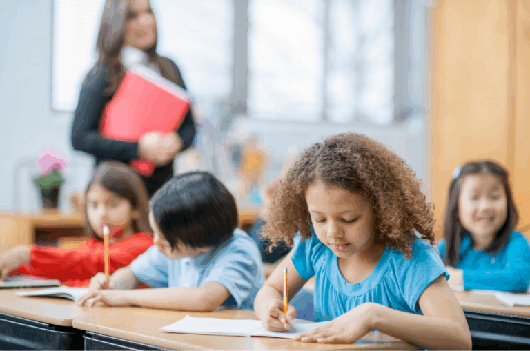 multi-ethnic girl student writing in elementary class during instruction